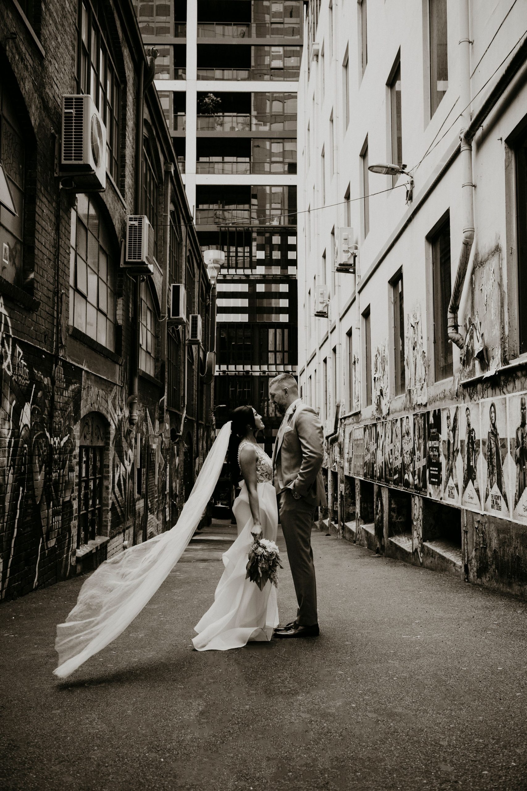 Couple in ACDC Lane vail blows in wind how to elope Intimate Wedding Melbourne Lets Elope Melbourne Celebrant Photographer Elopement Package Victoria Sarah Matler Photography Fitzroy Gardens Melbourne Laneways weddings intimate