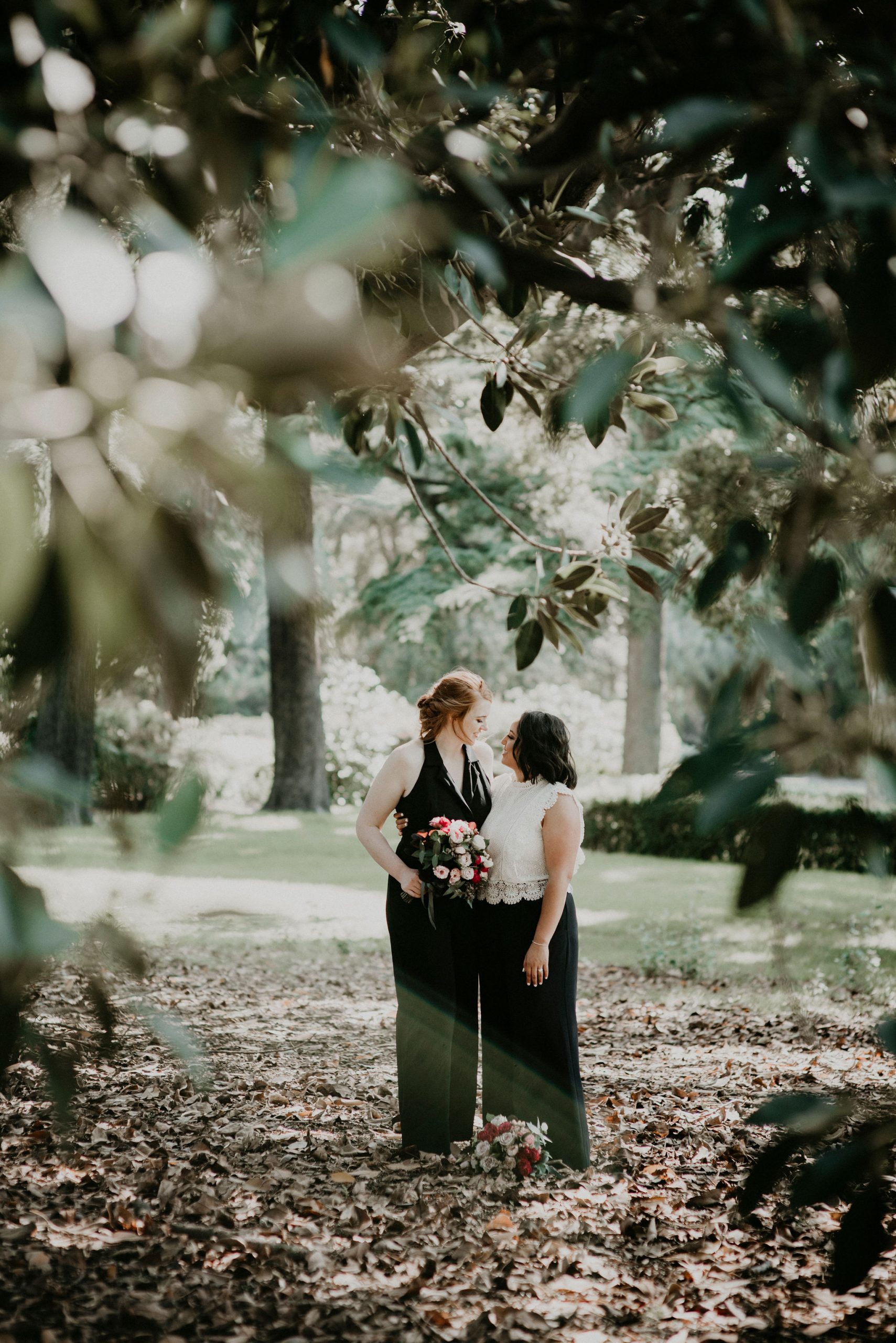 Summer Garden Wedding Couple Stands under tree in the Fitzroy Gardens