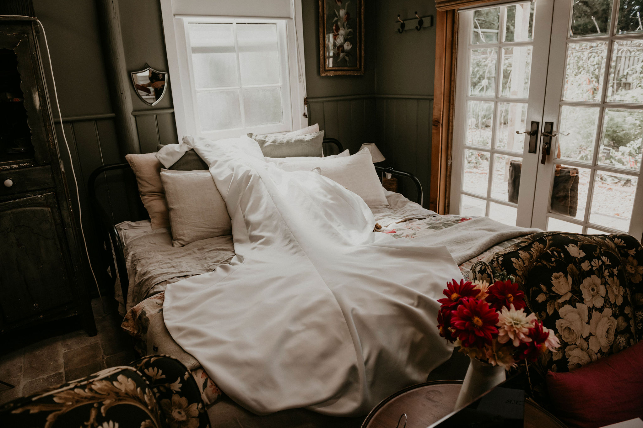 Wedding dress draped over bed in potters cottage while bride is getting ready before the ceremony Let's Elope Melbourne Portfolio Celebrant Photographer Elopement Packages Victoria Sarah Matler Photography intimate weddings Acre of Roses Trentham romantic ceremony
