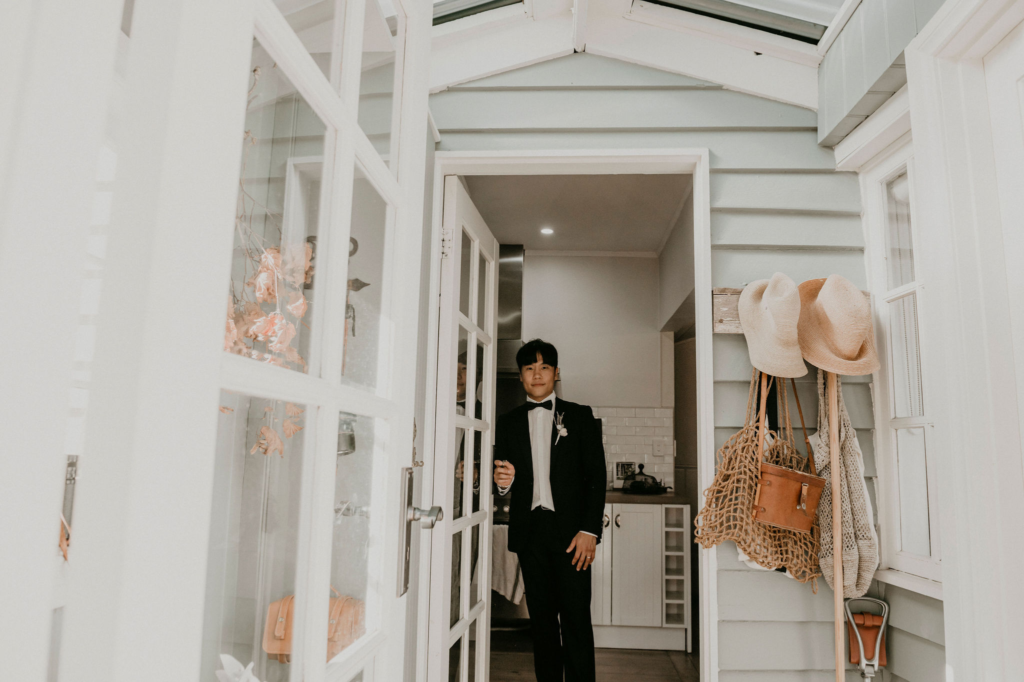Groom looking back through the door way towards photographer outside smiling after ceremony Let's Elope Melbourne Portfolio Celebrant Photographer Elopement Packages Victoria Sarah Matler Photography intimate weddings Acre of Roses Trentham romantic ceremony
